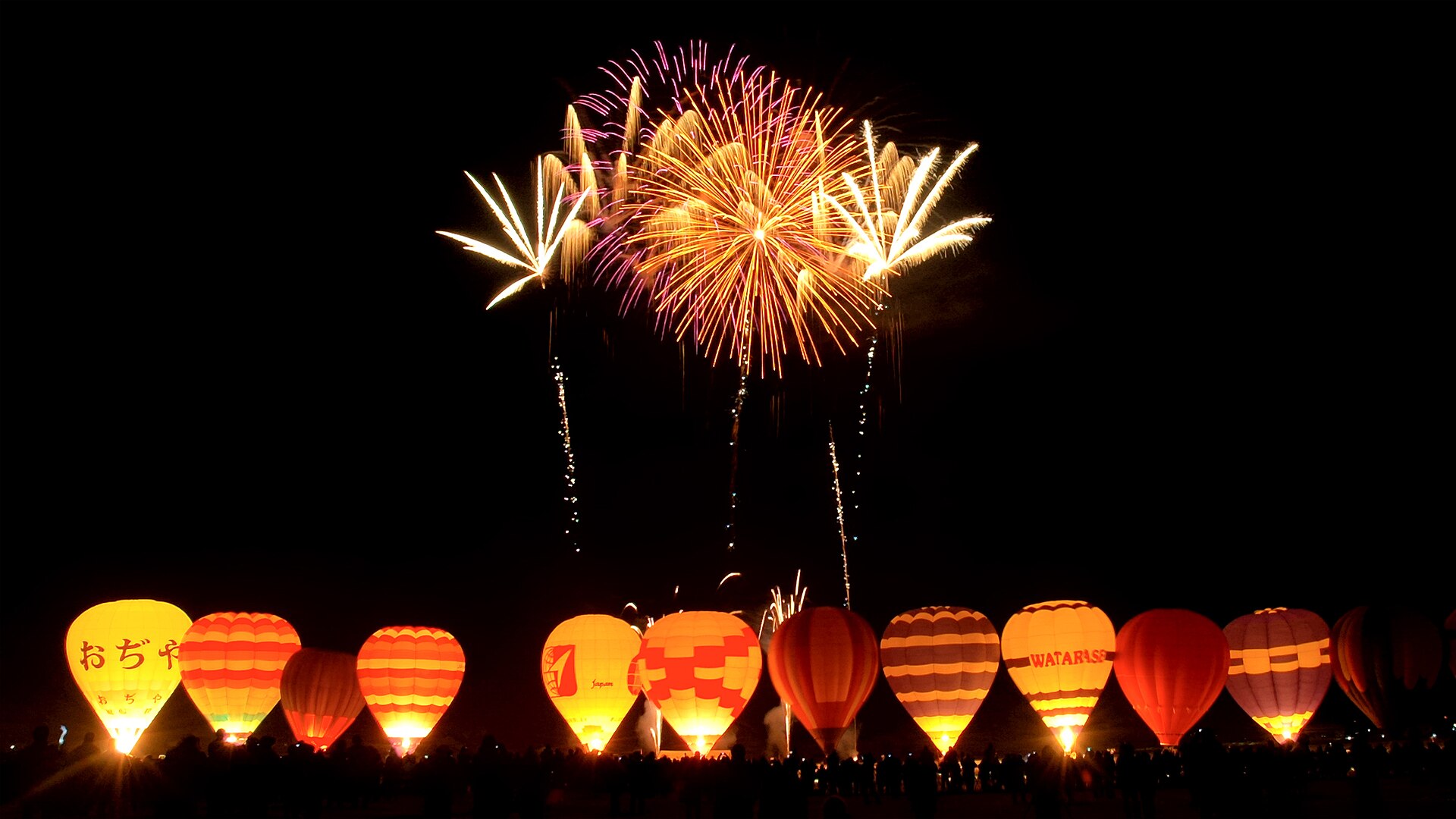 Fireworks and glowing balloons at a celebration