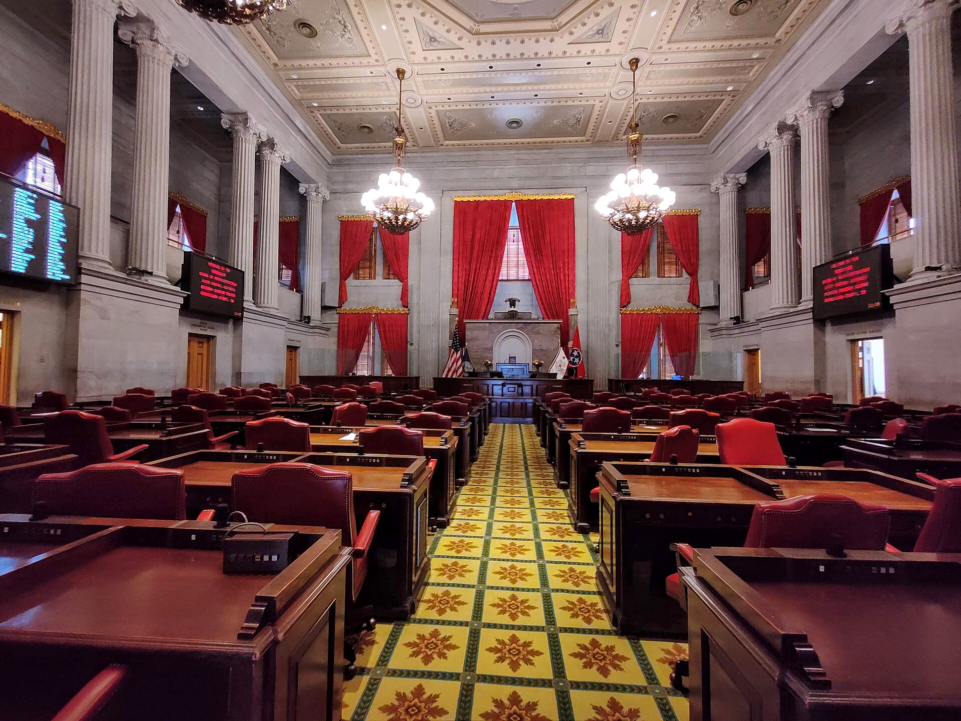State legislature chamber with red desks