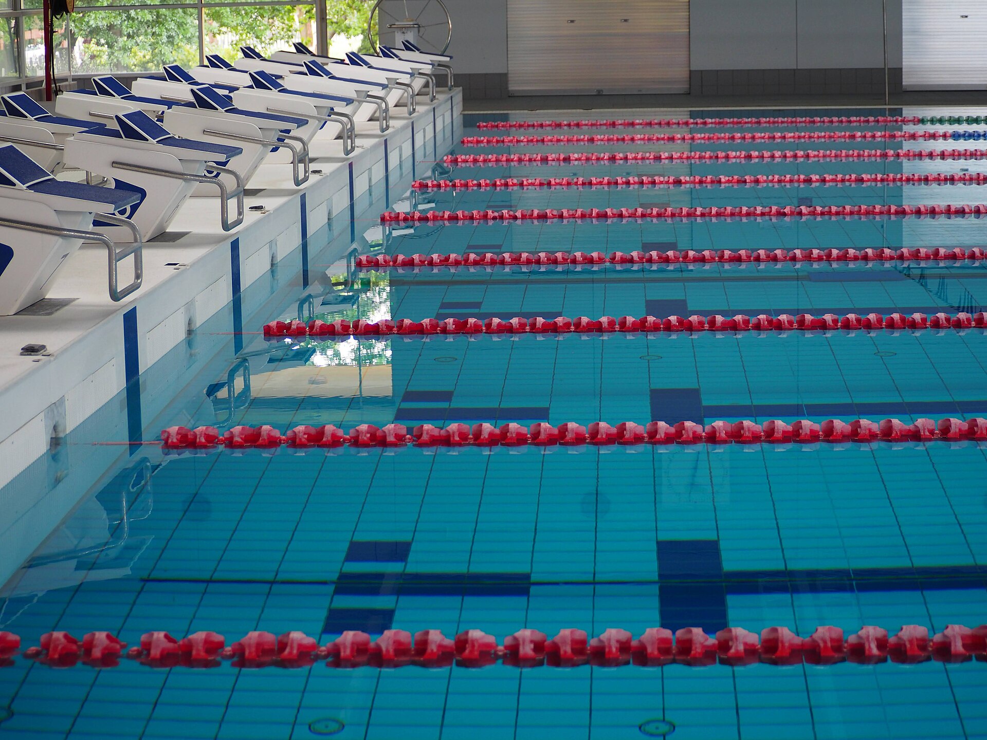 Swimming pool lanes beside a stone gymnasium
